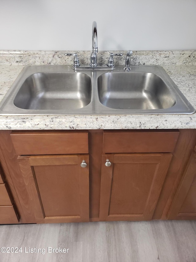 room details featuring light hardwood / wood-style flooring and sink