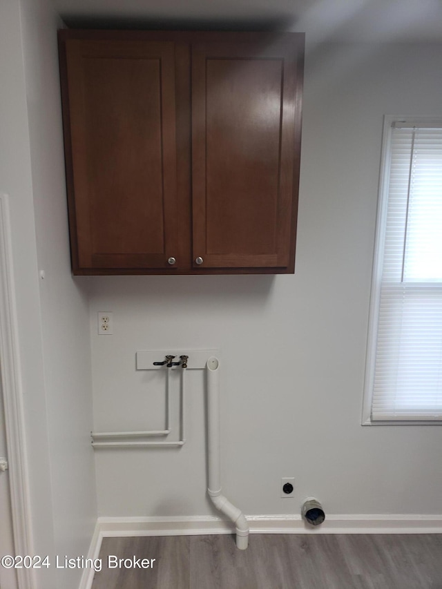 clothes washing area with washer hookup, hookup for an electric dryer, cabinets, and hardwood / wood-style floors