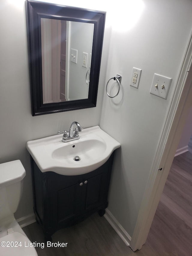 bathroom featuring hardwood / wood-style flooring, vanity, and toilet