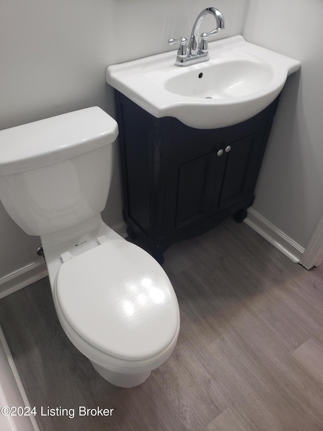 bathroom featuring vanity, hardwood / wood-style flooring, and toilet