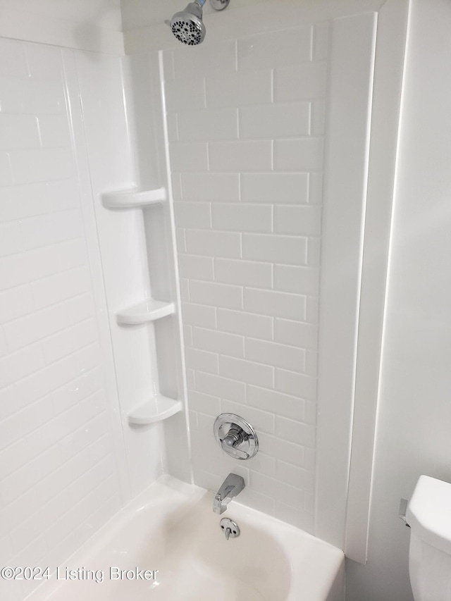 bathroom featuring tiled shower / bath combo and toilet