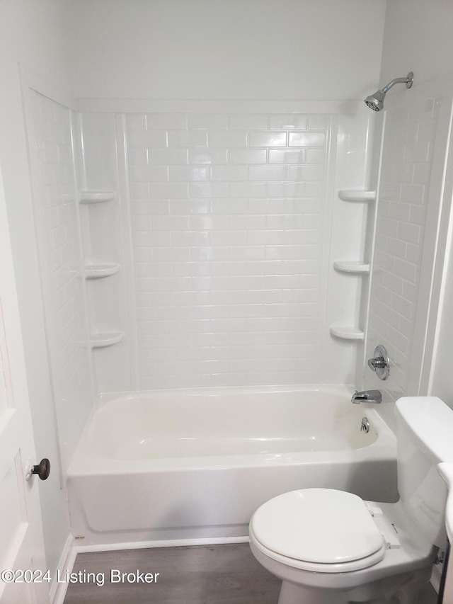 bathroom featuring tiled shower / bath, wood-type flooring, and toilet