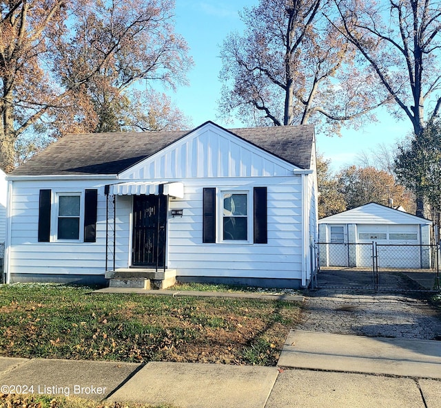 view of front facade featuring an outbuilding, a garage, and a front lawn