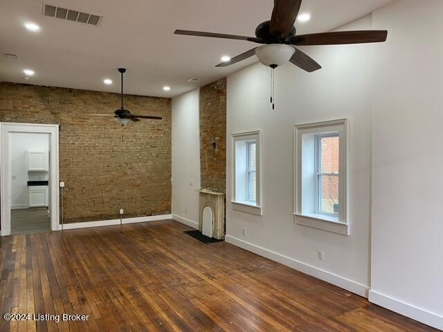 unfurnished living room featuring ceiling fan, a high ceiling, and dark hardwood / wood-style floors