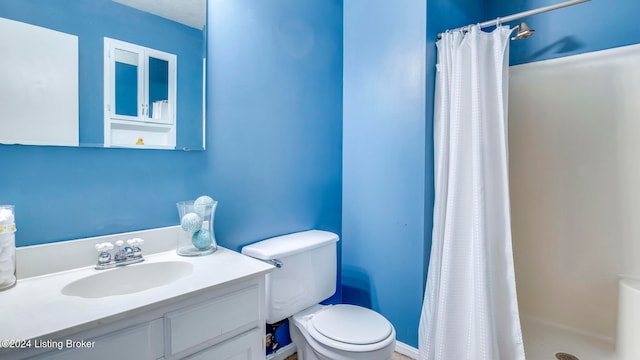 bathroom with vanity, toilet, and curtained shower