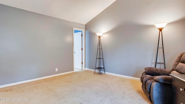 sitting room with light carpet and vaulted ceiling