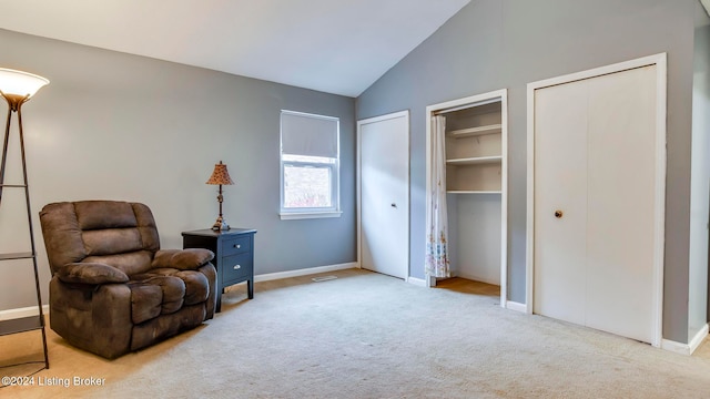 living area featuring lofted ceiling and light carpet