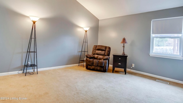 sitting room with carpet and vaulted ceiling