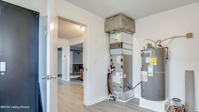 utility room with electric water heater and heating unit