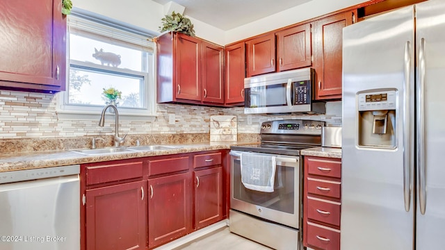 kitchen with backsplash, sink, and appliances with stainless steel finishes