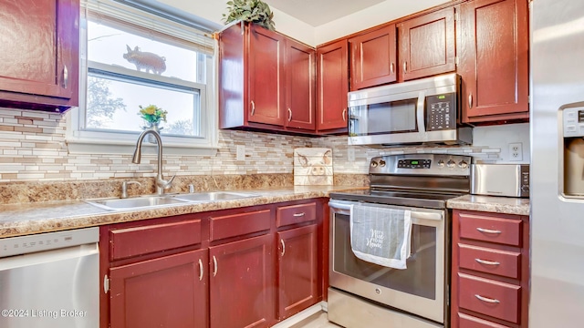 kitchen with appliances with stainless steel finishes, tasteful backsplash, and sink