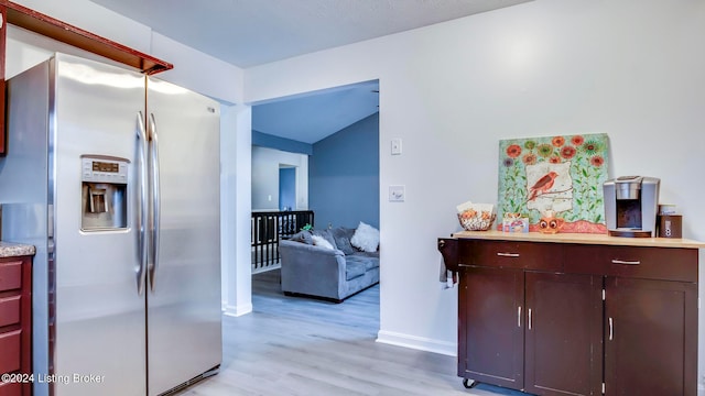 kitchen with stainless steel fridge with ice dispenser, light hardwood / wood-style floors, and lofted ceiling