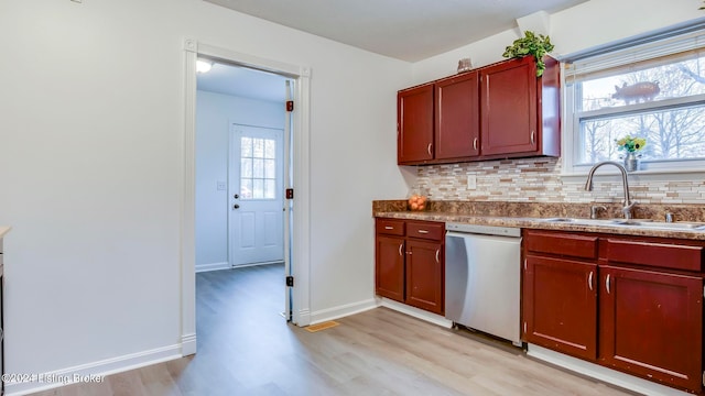 kitchen with sink, stainless steel dishwasher, plenty of natural light, and light hardwood / wood-style flooring