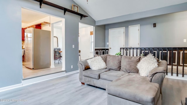 living room featuring high vaulted ceiling and light hardwood / wood-style floors