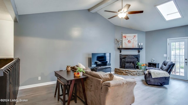 living room with a fireplace, lofted ceiling with skylight, hardwood / wood-style floors, and ceiling fan