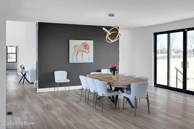 dining room with light hardwood / wood-style floors and an inviting chandelier