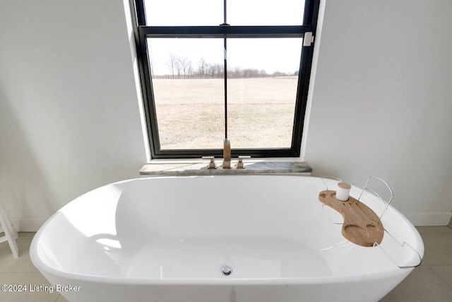 bathroom with tile patterned flooring and a washtub