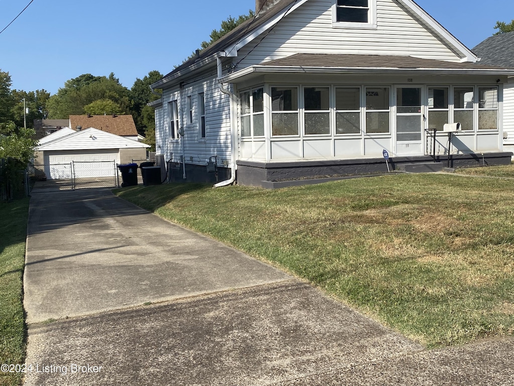 bungalow with a front lawn, an outdoor structure, and a garage