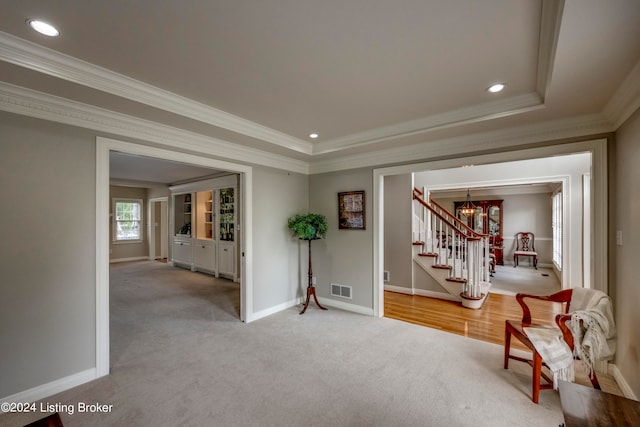 sitting room with carpet, crown molding, and an inviting chandelier