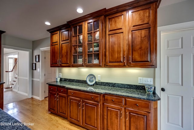 kitchen with dark stone countertops and light hardwood / wood-style flooring