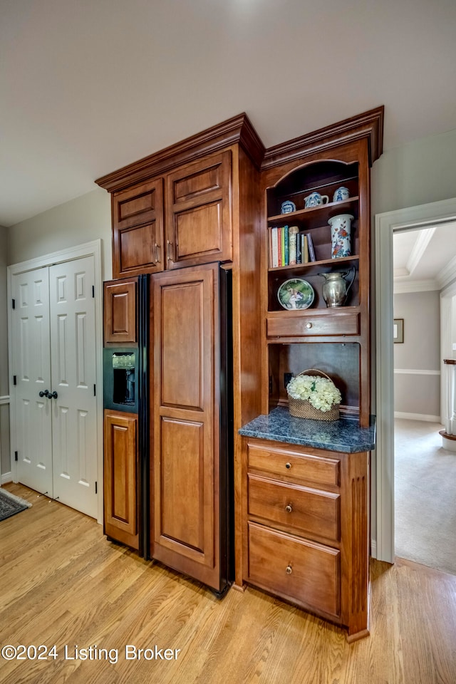 kitchen with paneled built in refrigerator, crown molding, and light hardwood / wood-style flooring