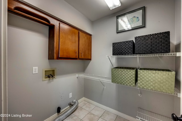 laundry room with cabinets, light tile patterned flooring, gas dryer hookup, and hookup for a washing machine