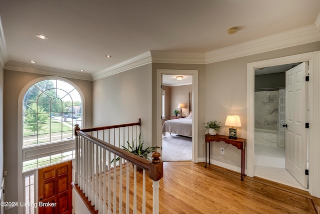 corridor featuring light wood-type flooring and ornamental molding