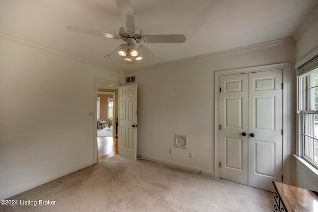 unfurnished bedroom featuring light carpet, a closet, ceiling fan, and ornamental molding