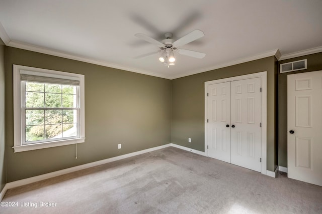 unfurnished bedroom with ceiling fan, a closet, light carpet, and ornamental molding