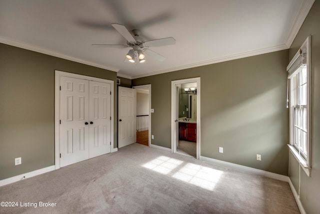 unfurnished bedroom with light carpet, ensuite bath, ceiling fan, and ornamental molding