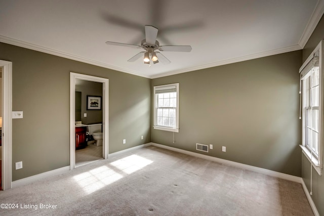 unfurnished bedroom featuring ceiling fan, ornamental molding, light carpet, and ensuite bath