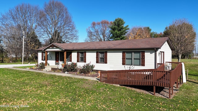 ranch-style home with a wooden deck and a front lawn