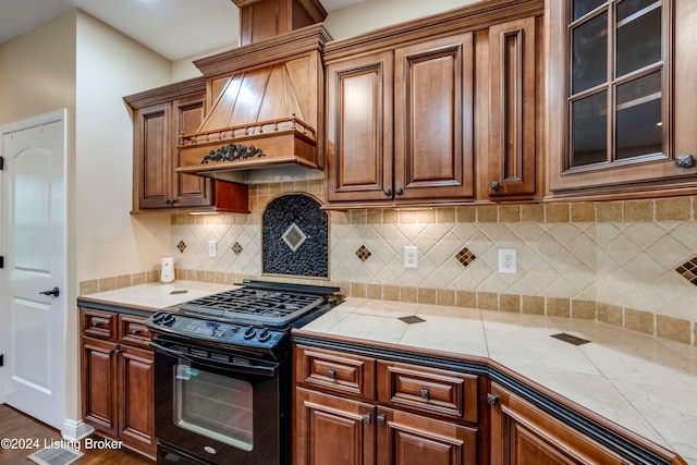 kitchen featuring custom exhaust hood, dark hardwood / wood-style flooring, black stove, and backsplash