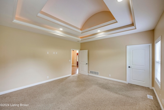 carpeted empty room featuring a tray ceiling