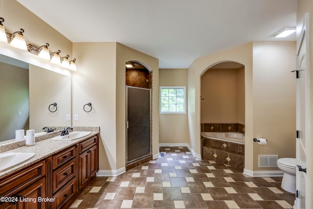 full bathroom featuring vanity, toilet, and independent shower and bath