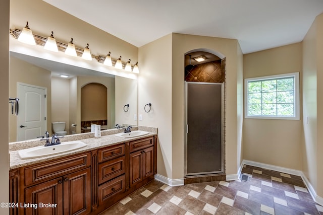 bathroom featuring vanity, toilet, and a shower with door