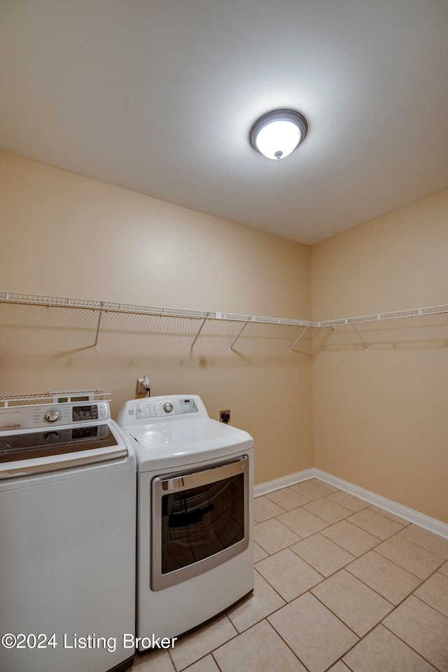 clothes washing area with light tile patterned floors and separate washer and dryer