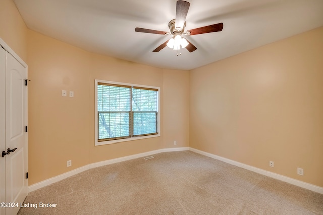 empty room with ceiling fan and light colored carpet