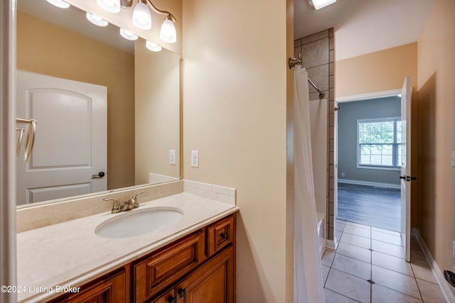 bathroom with shower / bath combo with shower curtain, tile patterned flooring, and vanity