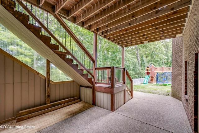 view of patio with a trampoline and a playground