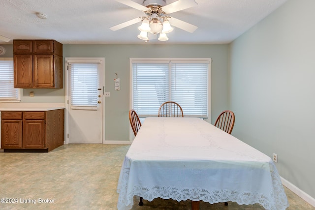 dining space featuring ceiling fan and a textured ceiling