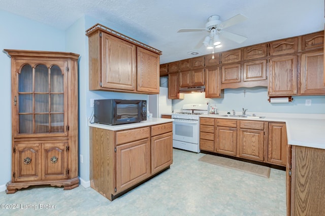 kitchen with ceiling fan, sink, white range with gas stovetop, and a textured ceiling