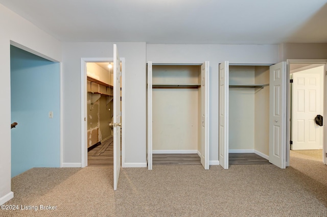 unfurnished bedroom with carpet and two closets