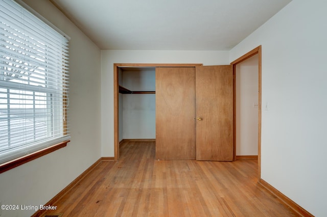 unfurnished bedroom featuring light hardwood / wood-style floors and a closet