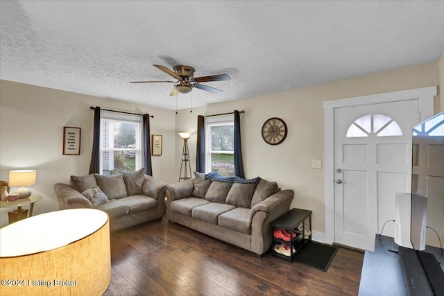 living room featuring a textured ceiling, ceiling fan, and dark wood-type flooring