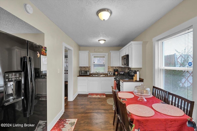 kitchen with white cabinetry, dark hardwood / wood-style floors, white range with gas cooktop, decorative backsplash, and black fridge with ice dispenser