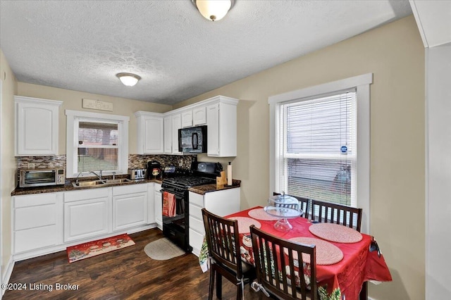 kitchen with sink, dark hardwood / wood-style flooring, backsplash, white cabinets, and black appliances