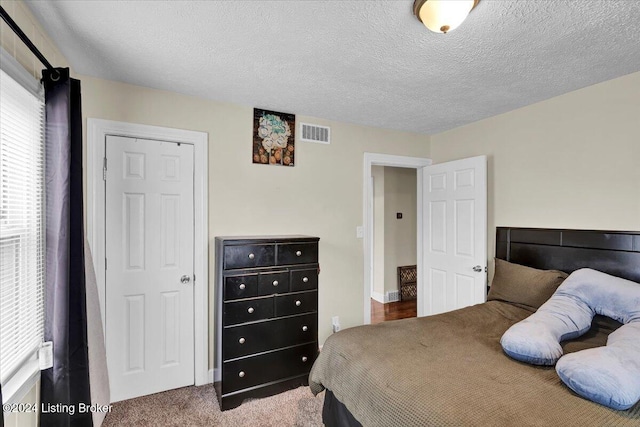 carpeted bedroom with a textured ceiling