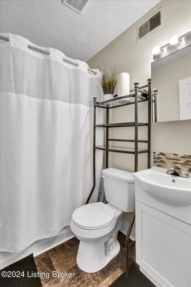 bathroom with a shower with shower curtain, tasteful backsplash, vanity, a textured ceiling, and toilet