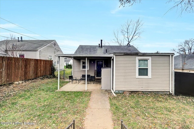 back of property featuring a patio area and a lawn